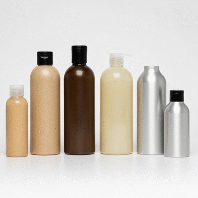 Assortment of eco-friendly body wash bottles made from PCR plastic, bioplastic, glass, and aluminum, clean image