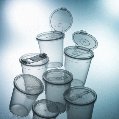 Assortment of clear plastic cups with various lids on a clean table